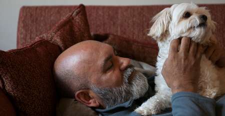 Man with the dog lying on a couch