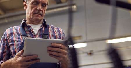 Middle-aged man looking down at his ipad