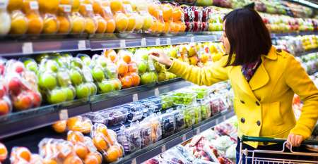 Woman in supermarket holding trolley selecting food