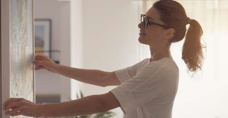 Young woman hanging a picture