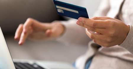 Woman shopping online with bank card