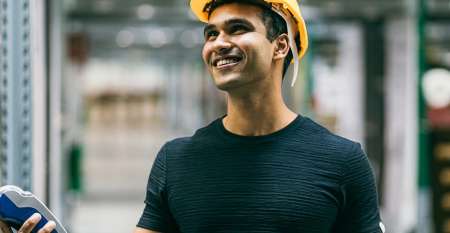 Young man in safety helmet stocktaking