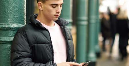Young man using mobile phone in street