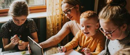 Woman with three children drawing