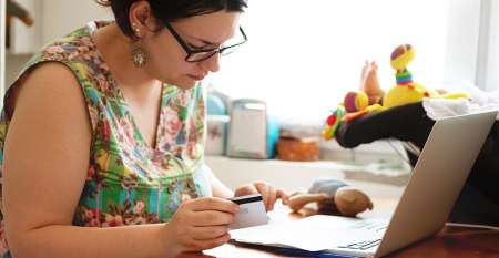 Young woman paying bills online from home